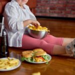 Ultra-Processed Foods: Are They Rigging Your Appetite? Child sitting on the floor enjoying snacks from a bowl