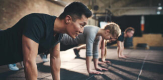 Group of individuals performing push-ups in a gym