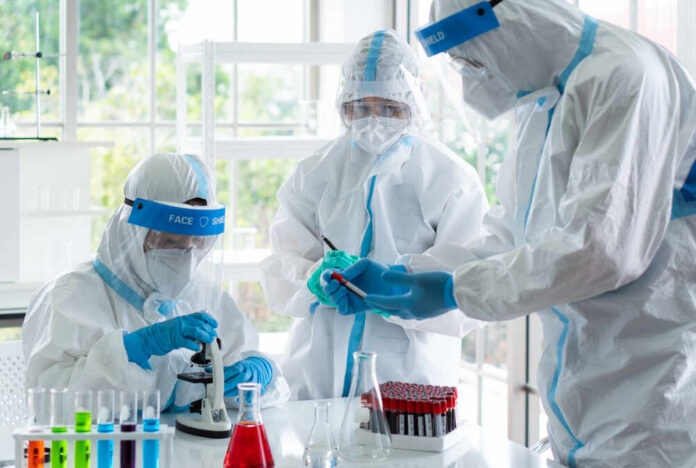 shutterstock_1714108444.jpg Scientists in protective suits conducting research in a laboratory