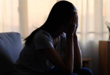 Emotional Suppression—The Shocking Health Risk A silhouette of a person sitting with their head in their hands, conveying distress