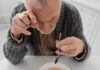 Nutrient Crisis Threatens Seniors’ Lives Elderly man focusing intently on a spoon while preparing to eat