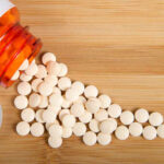 Weight-Loss Drug Twist: Steps Plunge? Spilled white pills from a prescription bottle on a wooden surface
