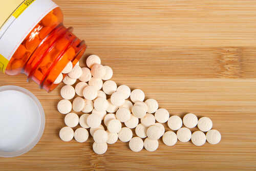Alameda,,Ca,-,Apr,29,,2020:,Top,View,Flat,Lay Spilled white pills from a prescription bottle on a wooden surface