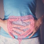 Calcium Intake and Risk of Colon Cancer Person holding their stomach with a graphic of intestines overlayed