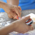 Prediabetes: What It Is, Symptoms, and How To Reverse Hands labeling an item with a small tag while holding a measuring device
