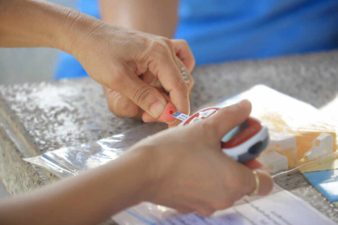 Hands labeling an item with a small tag while holding a measuring device