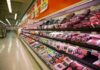Grocery store meat aisle stocked with packaged beef and poultry