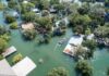 Aerial view of flooded neighborhood with rescue boat navigating streets