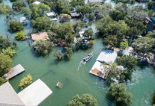 Aerial view of flooded neighborhood with rescue boat navigating streets