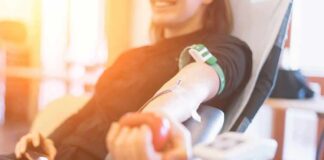 Person donating blood while squeezing a red ball