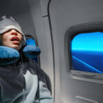Ignored Snoring, Parkinson’s Later? A passenger sleeping on an airplane with headphones and an eye mask
