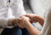 Doctor holding patient’s hands in support