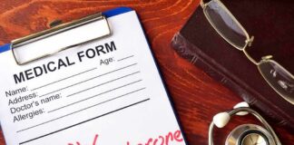 medical form on clipboard with stethoscope and glasses