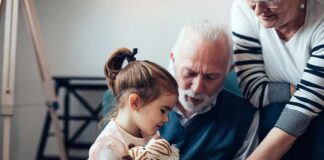 Child with stuffed tiger sitting with elderly couple