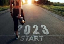 Runner stretching at start line on rural road at sunrise