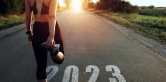 Runner stretching at start line on rural road at sunrise