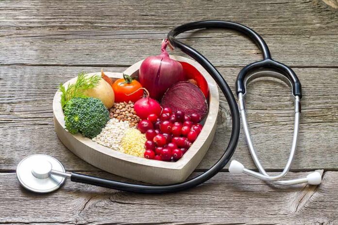 Heart-shaped bowl with fruits, vegetables, grains and a stethoscope