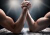 Two muscular arms locked in an arm wrestling match
