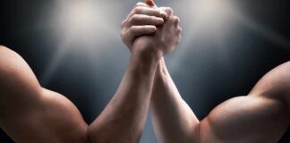 Two muscular arms locked in an arm wrestling match
