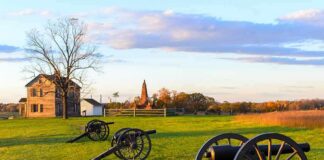 Civil War cannons on a grassy battlefield at sunset
