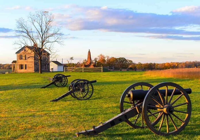 shutterstock_121440904 Civil War cannons on a grassy battlefield at sunset