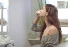woman in bathroom using nasal spray