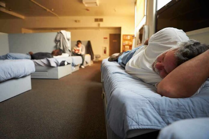 Man resting on a bunk in a shared dormitory room