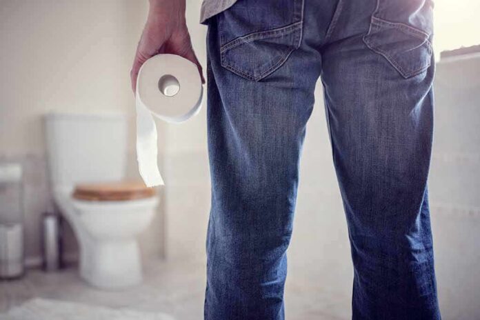 Person holding a toilet paper roll in a bathroom