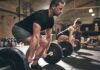 Two people performing deadlifts in a gym